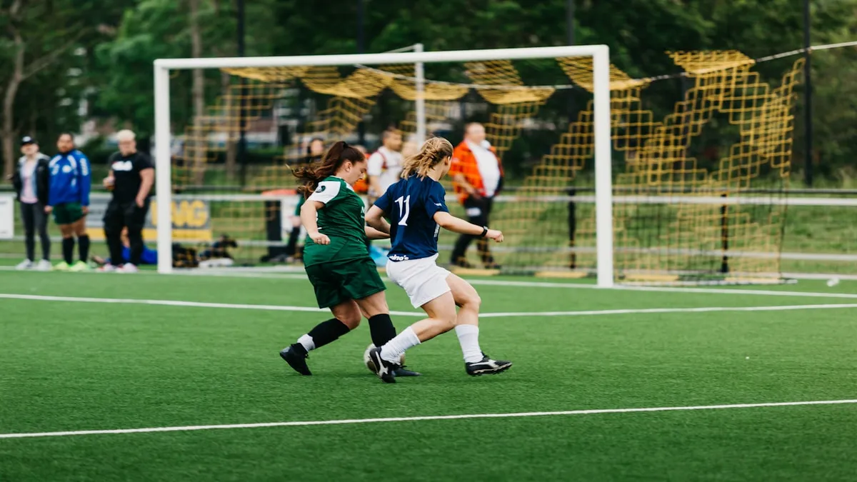 A soccer player celebrating a goal with teammates in the background